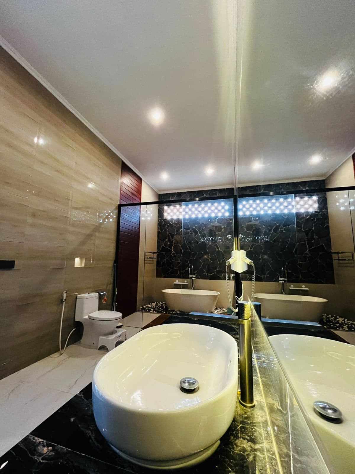 Bathroom with a freestanding tub set against a stone wall