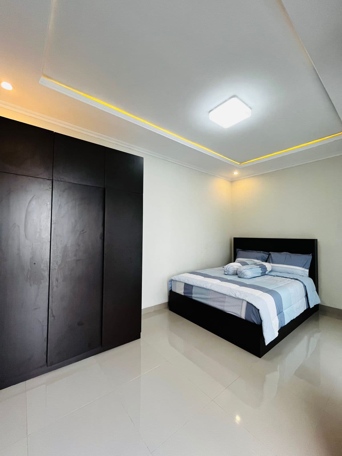 Bedroom with a dark timber wardrobe wall