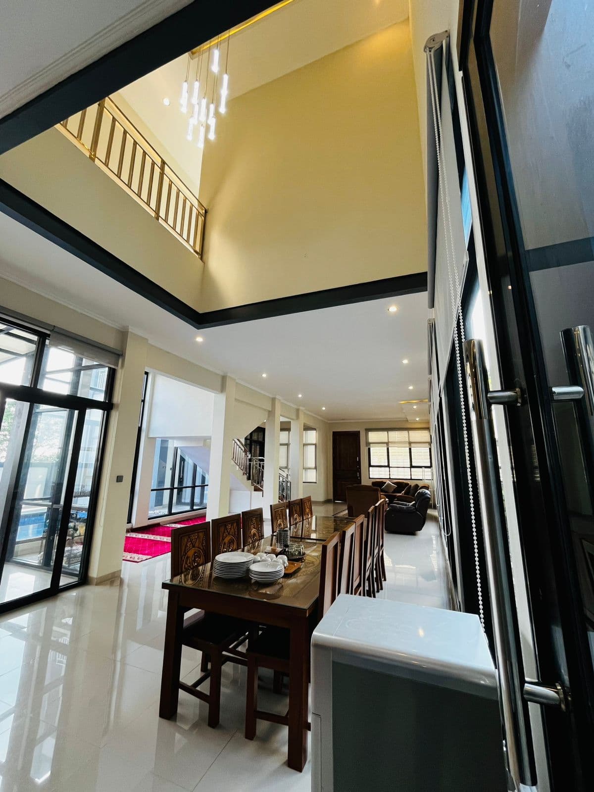 Double-height dining room with tall windows at the villa