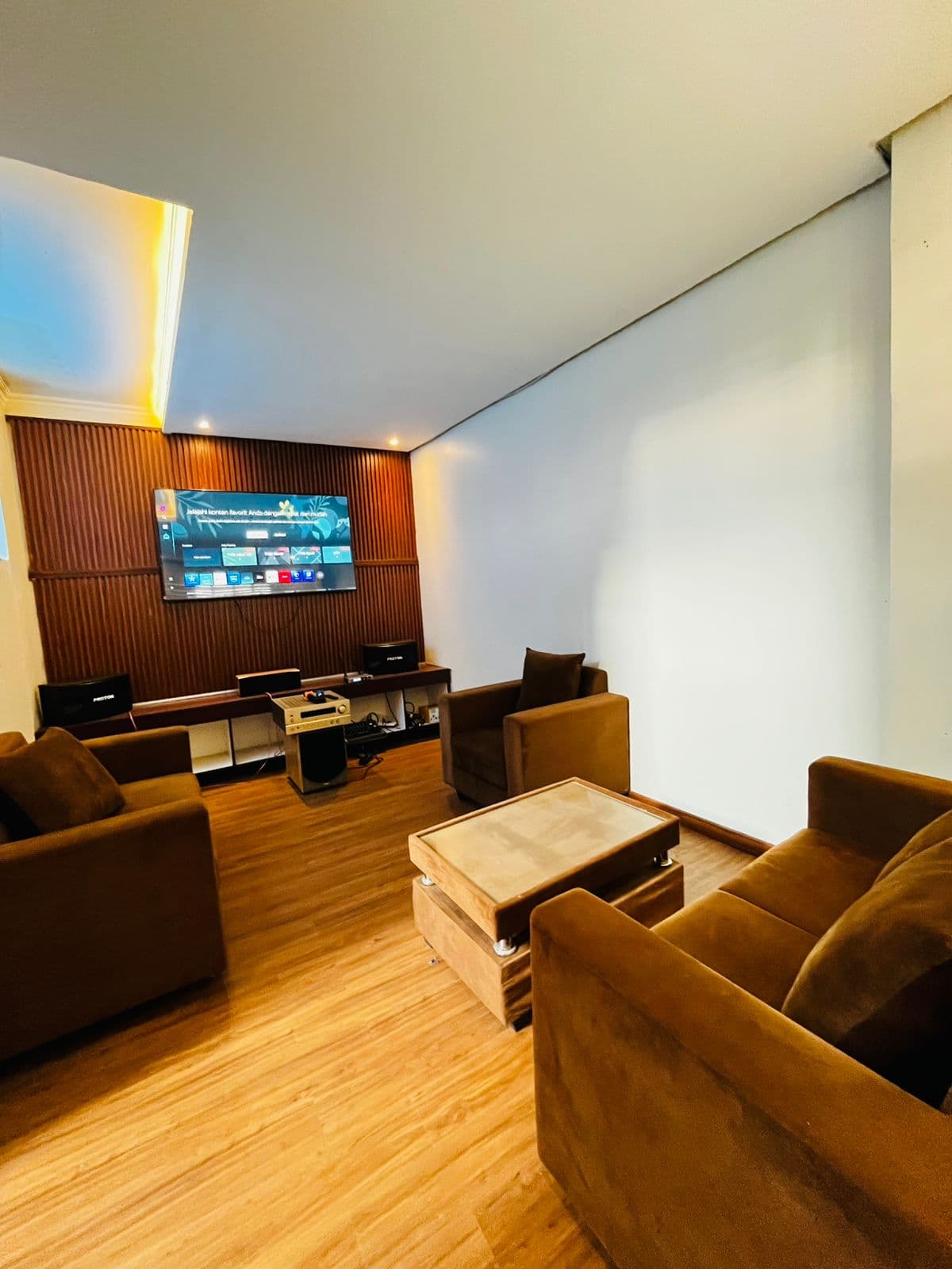 Living room with brown sofas and a timber feature wall