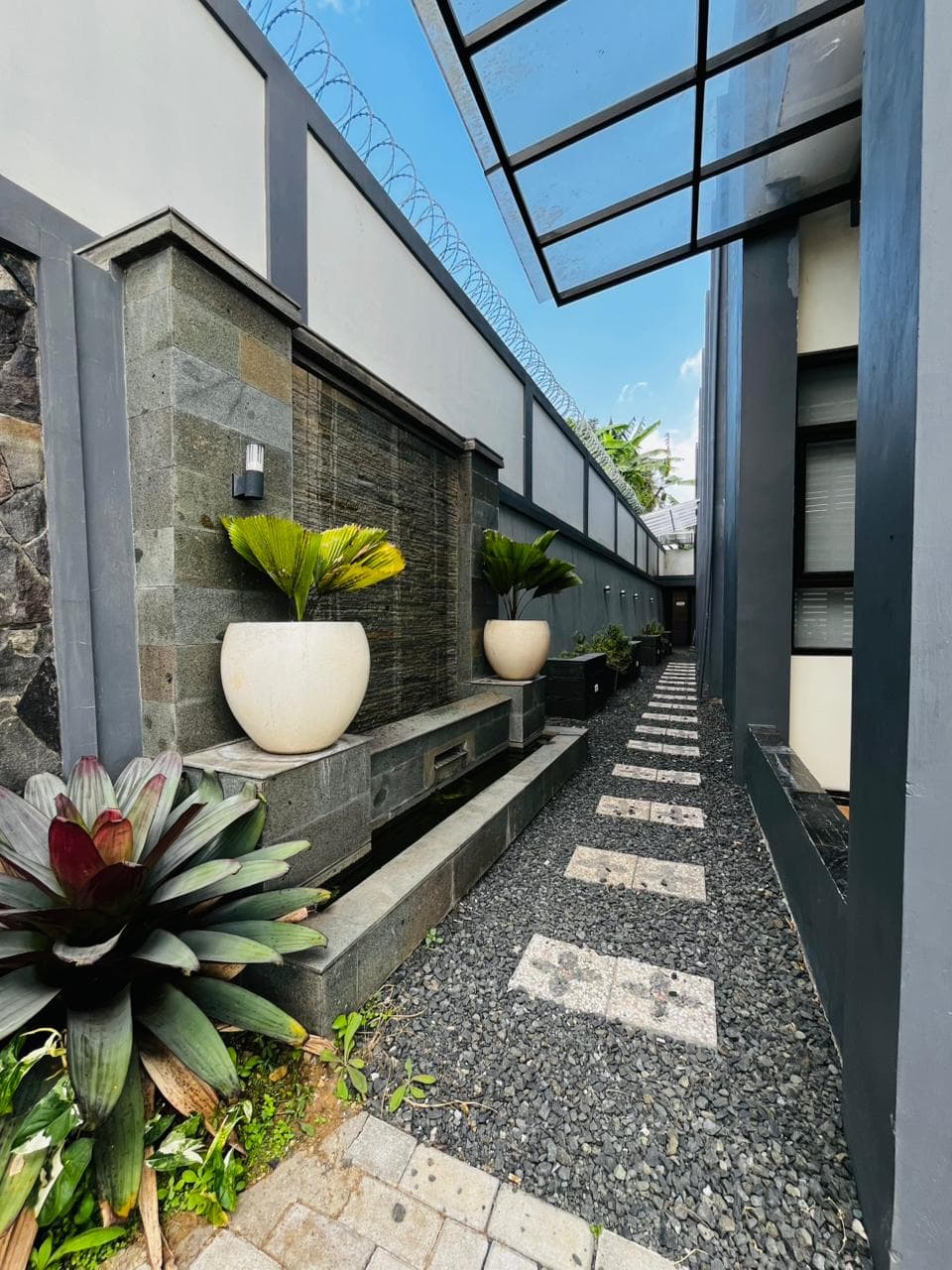 Planted side path with stepping stones along the villa wall
